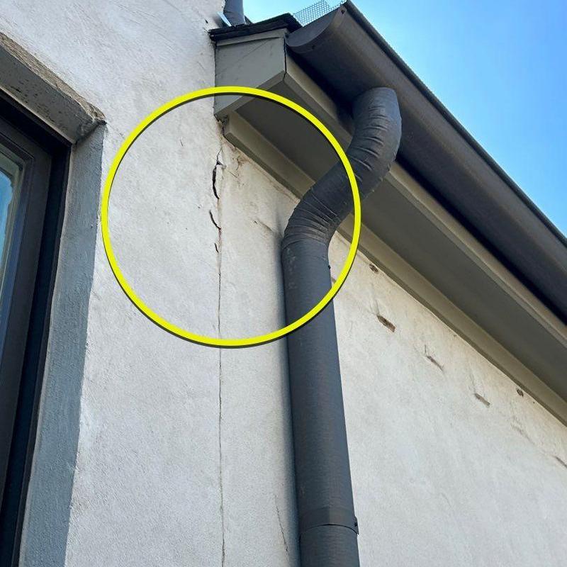 Stucco wall cracks next to downspout and roofline Stucco wall cracks next to downspout and roofline