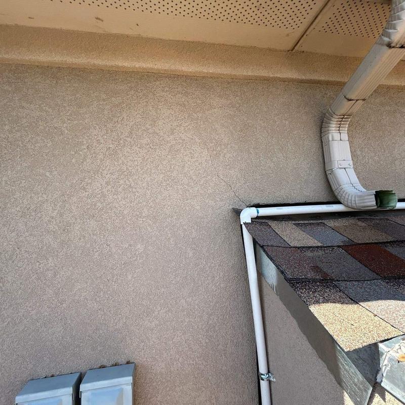 Stucco terrace wall with adjoining shingle roof section Stucco terrace wall with adjoining shingle roof section