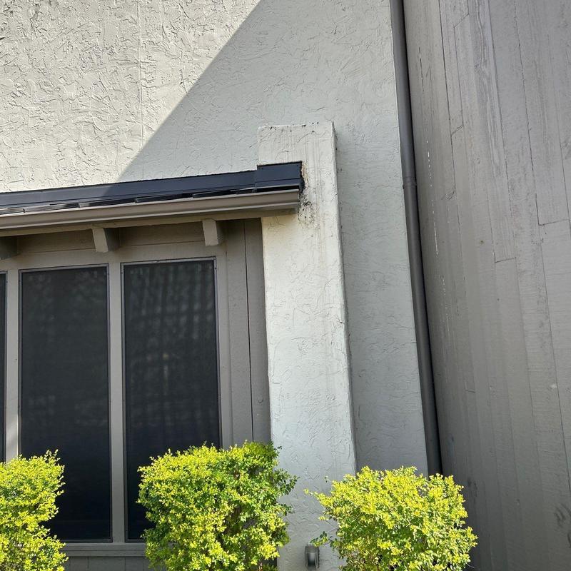 Stucco wall damage near window and downspout Stucco wall damage near window and downspout