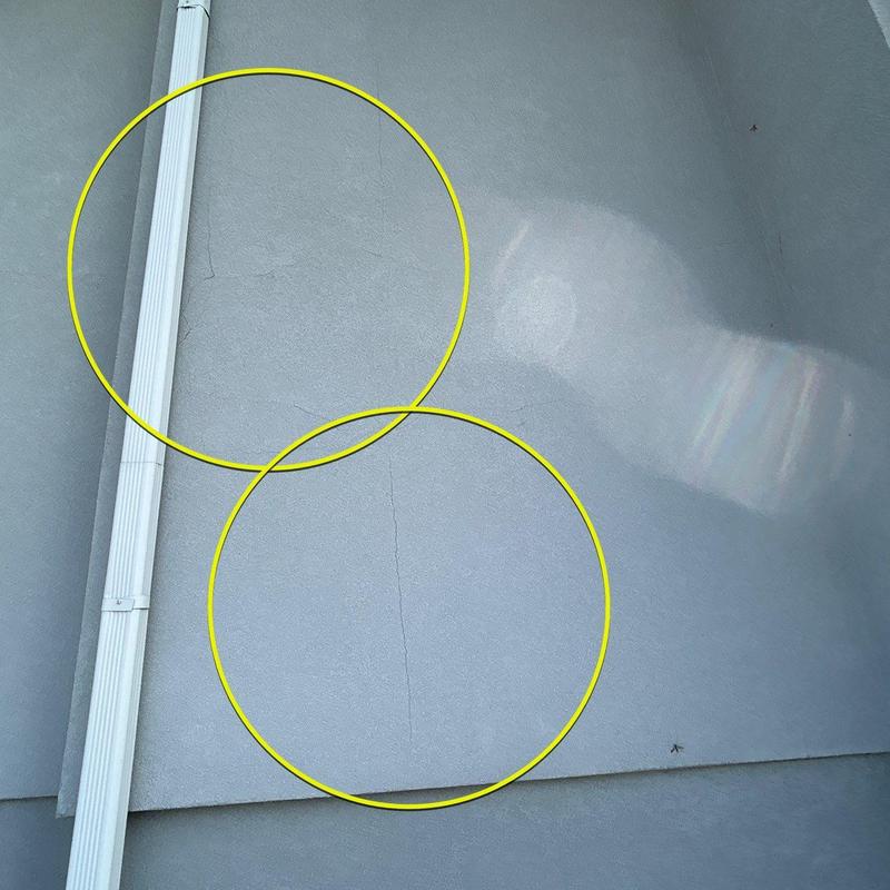 Exterior stucco cracks near downspout at residence Exterior stucco cracks near downspout at residence