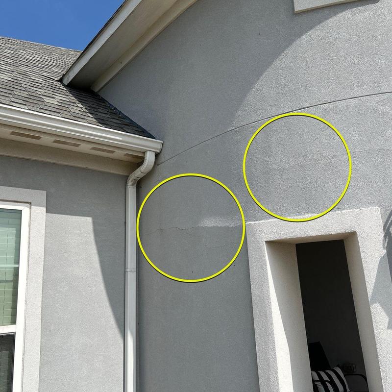 Exterior stucco wall cracks near downspout and doorway Exterior stucco wall cracks near downspout and doorway