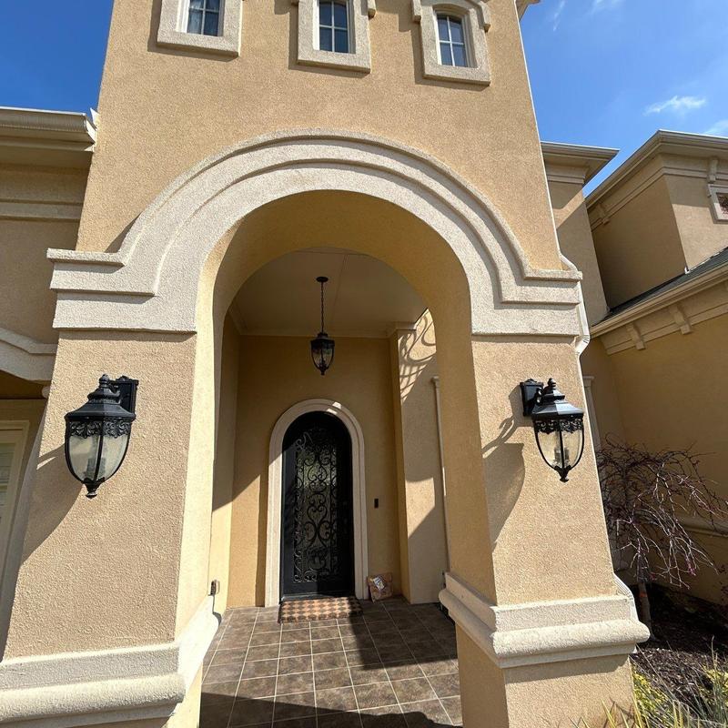Exterior stucco near arched entryway and door trim Exterior stucco near arched entryway and door trim