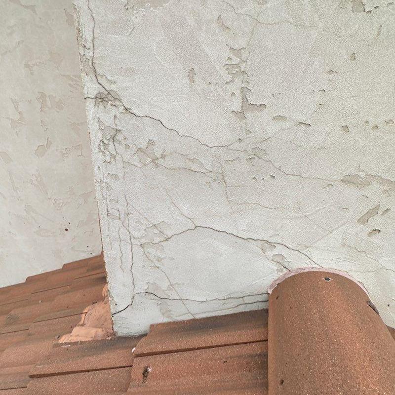 Chimney stucco with cracks above tiled roof edge Chimney stucco with cracks above tiled roof edge