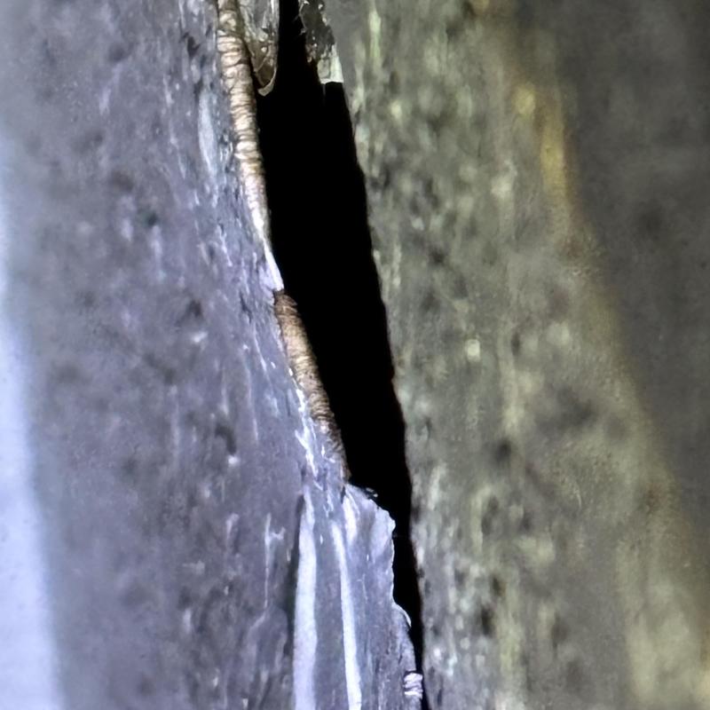 Weld seam crack in metal pipe close-up view Weld seam crack in metal pipe close-up view