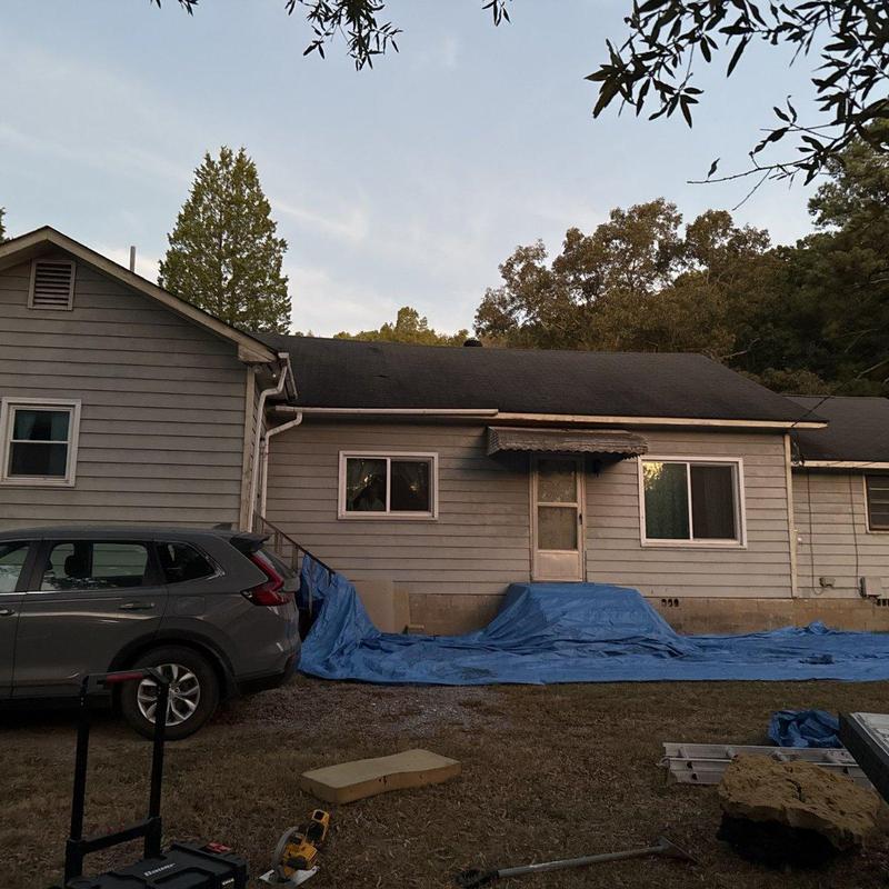 Asphalt shingle roof with protective blue tarp setup Asphalt shingle roof with protective blue tarp setup