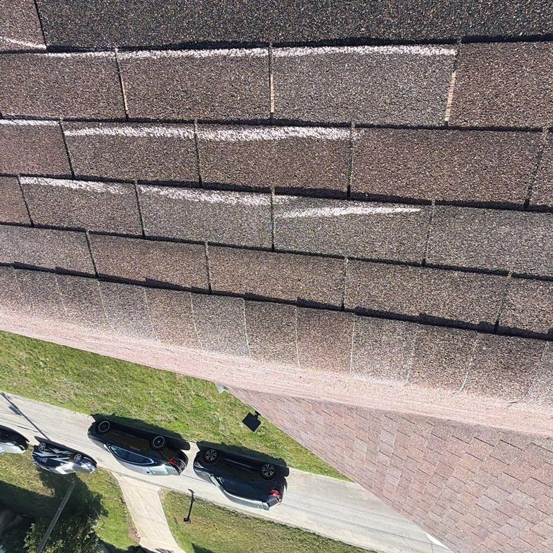 Asphalt roof shingles with hail impact marks