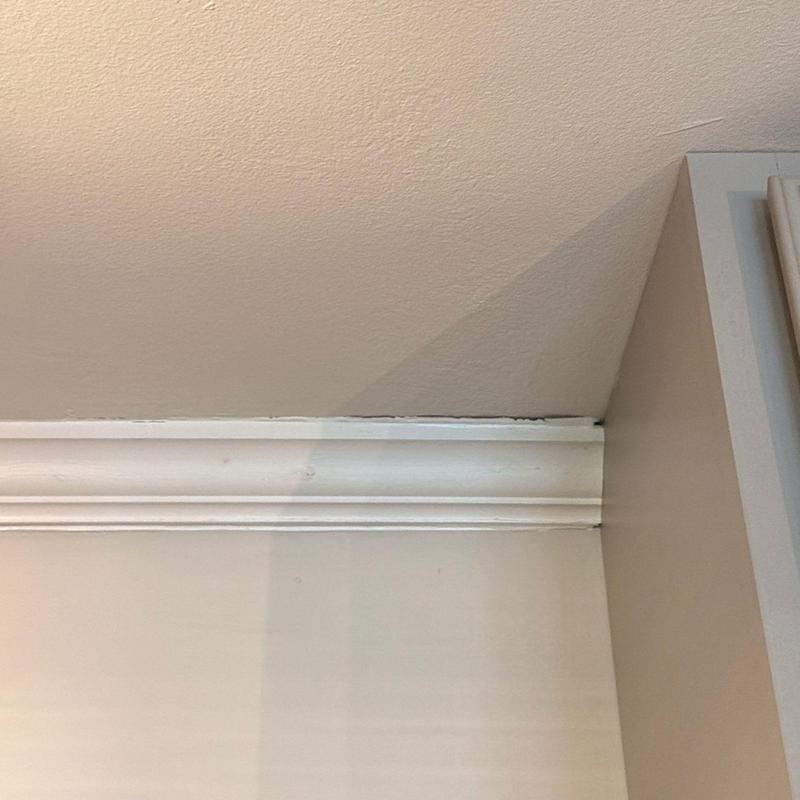 Crown molding with paint discoloration near ceiling