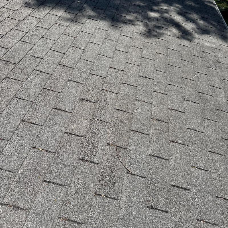 Asphalt roof shingles with hail damage and wear