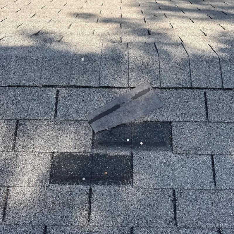 Asphalt roof shingles with lifted and patched areas