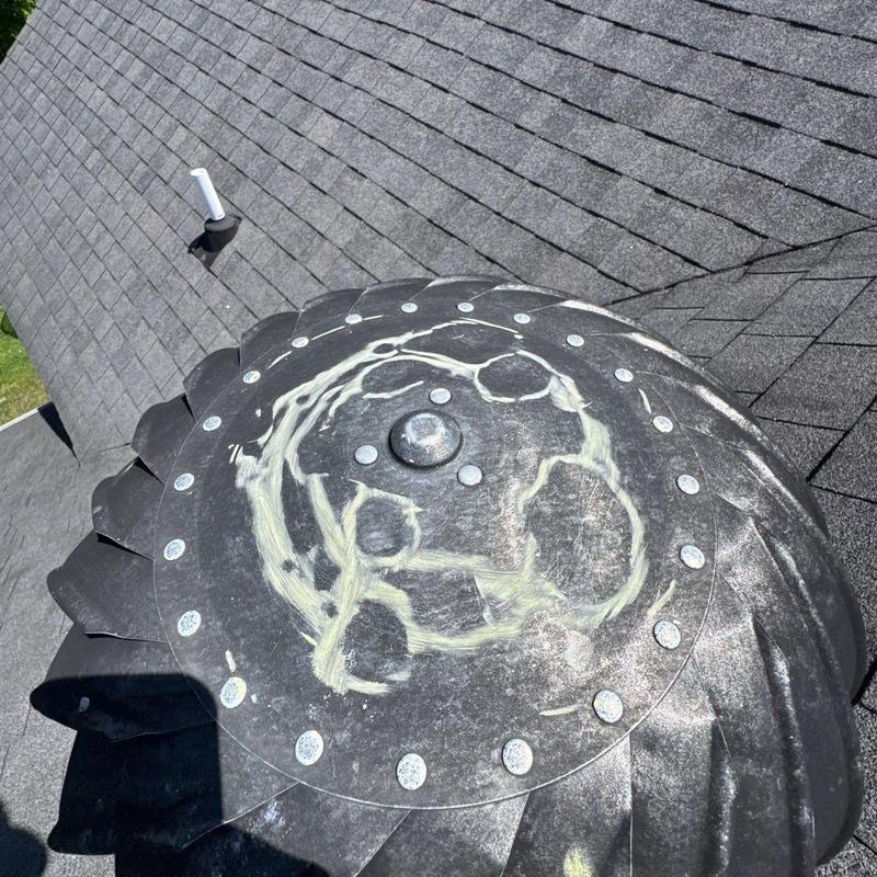 Roof vent with marked hail damage on shingles