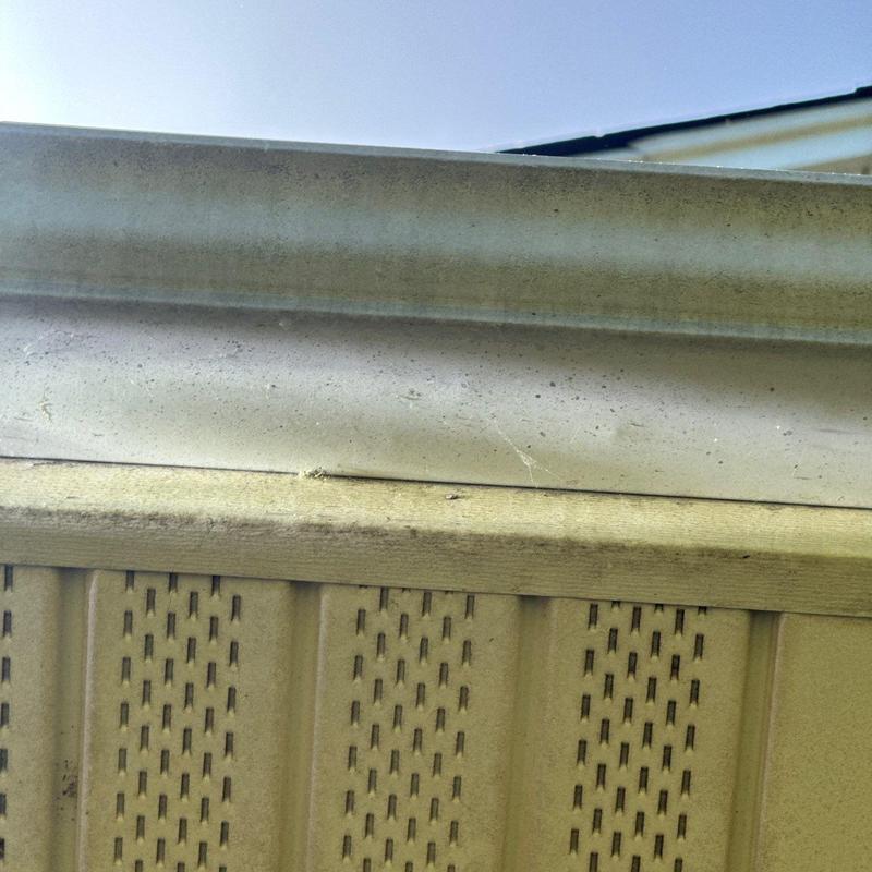 Metal gutter with dirt and discoloration buildup