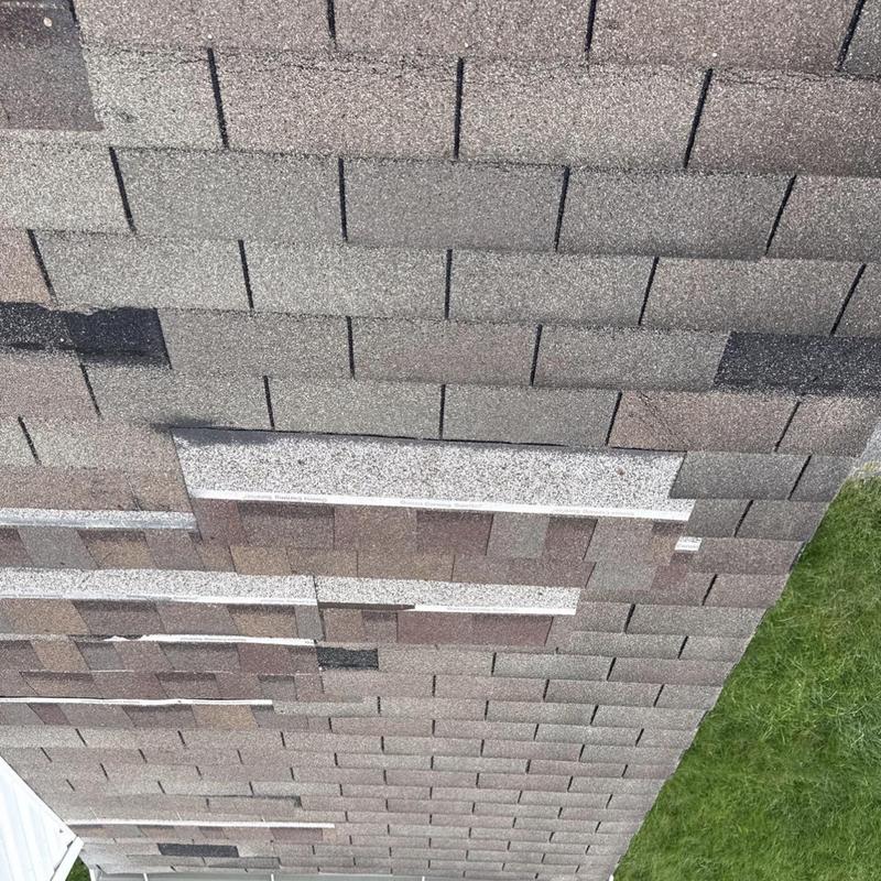 Roof shingles with damage and missing pieces on roof edge