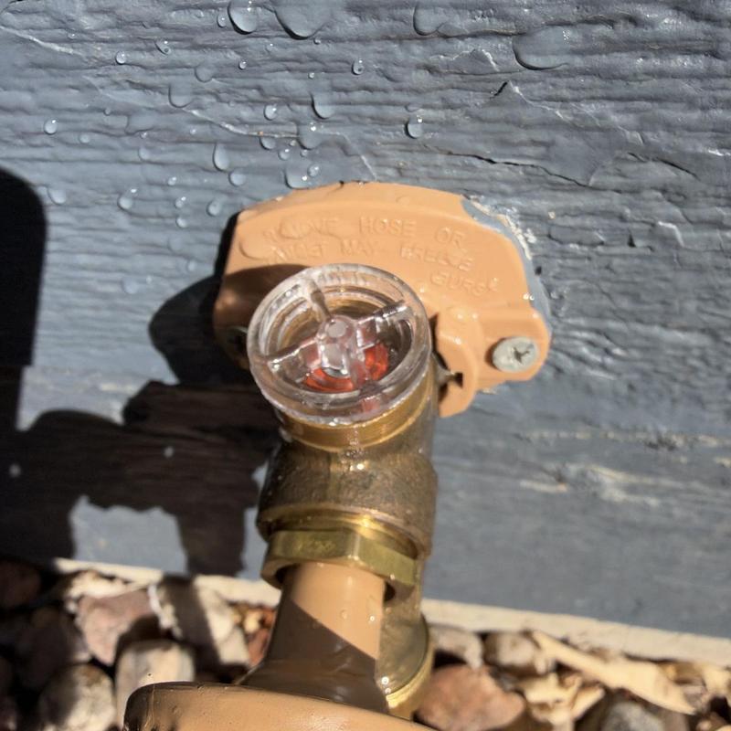 Hose bibb with backflow preventer on exterior wall