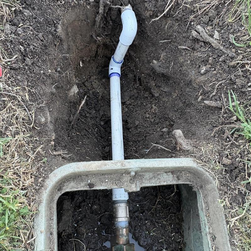 Water main piping with PVC and metal fittings in trench