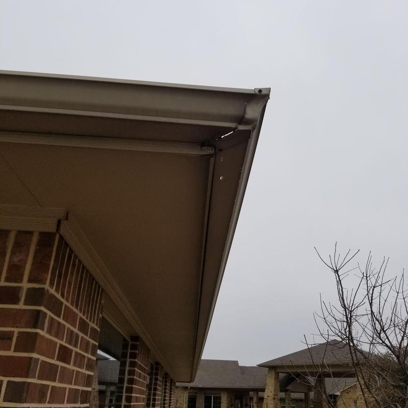 Metal gutter with corner damage on brick house exterior Metal gutter with corner damage on brick house exterior