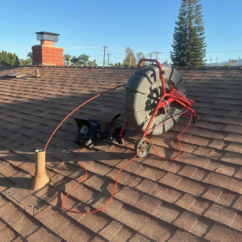 Sewer line drain-cleaning machine and inspection camera on roof