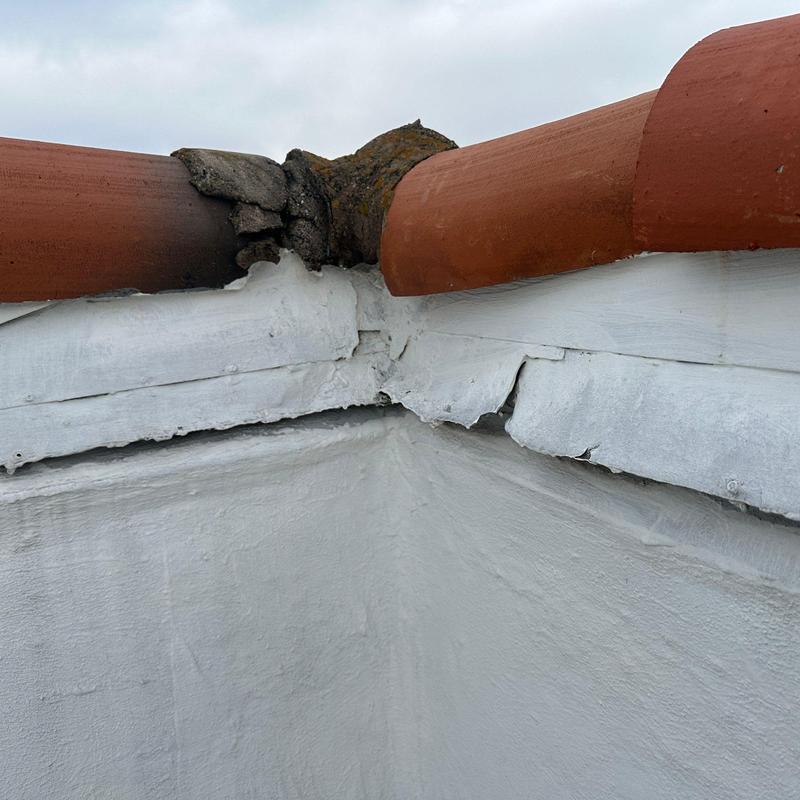 Concrete roof corner with damaged flashing and tiles Concrete roof corner with damaged flashing and tiles