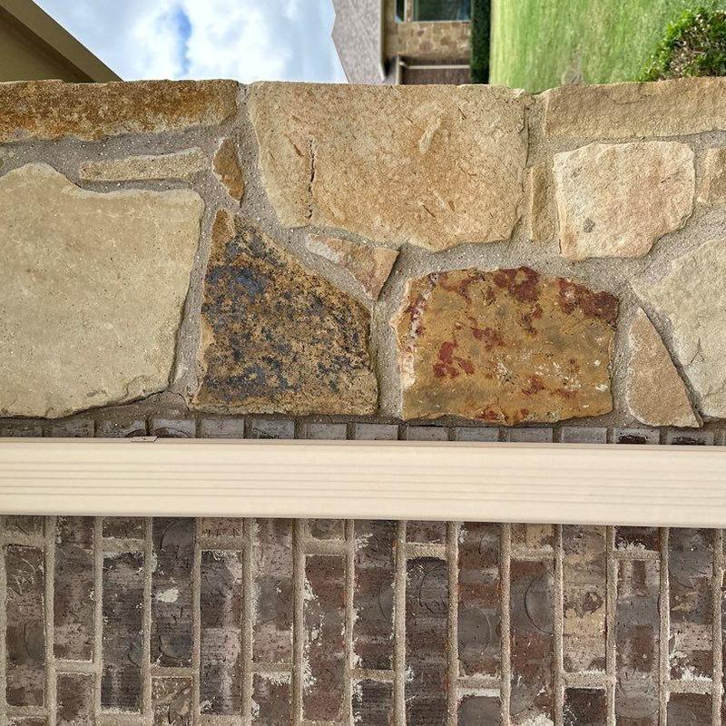 Stone veneer repair along brick and roofline exterior Stone veneer repair along brick and roofline exterior