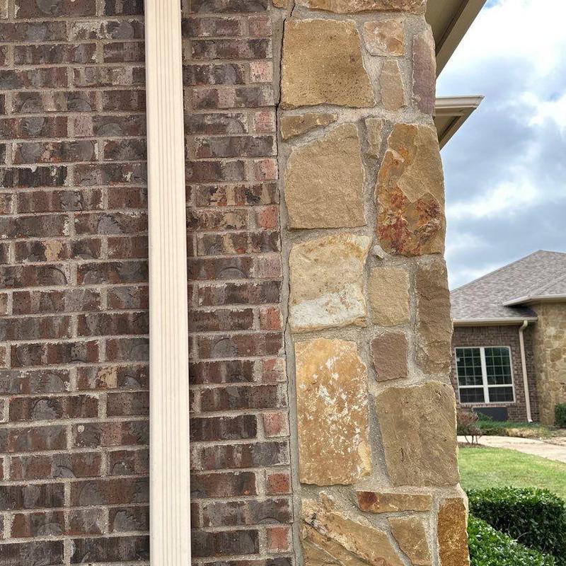 Stone veneer masonry on building exterior near roofline Stone veneer masonry on building exterior near roofline
