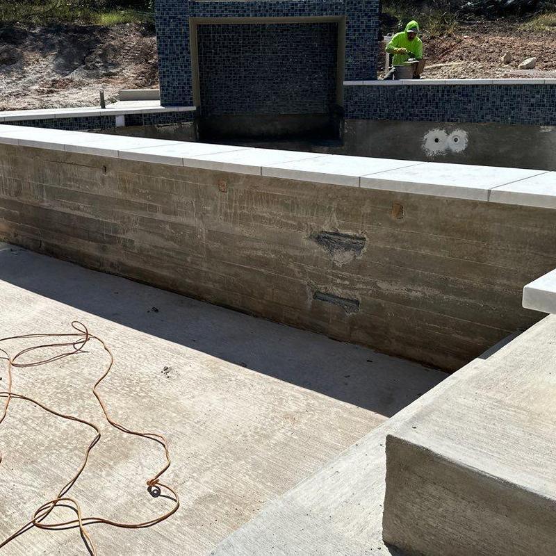 Concrete pool wall with tile water feature installation Concrete pool wall with tile water feature installation