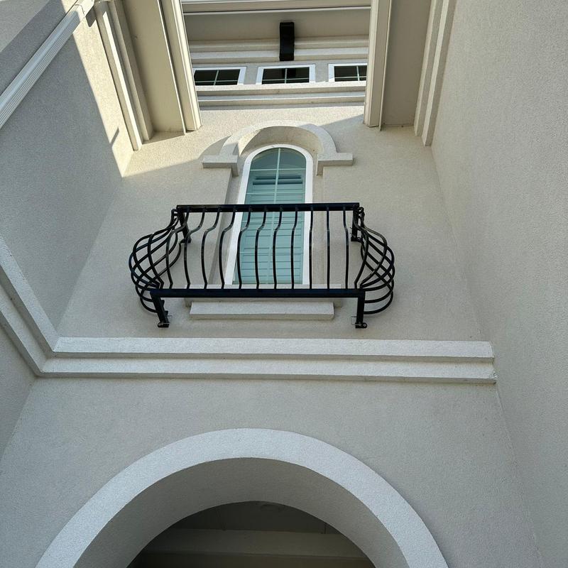 Stucco exterior wall patch near arched balcony window Stucco exterior wall patch near arched balcony window