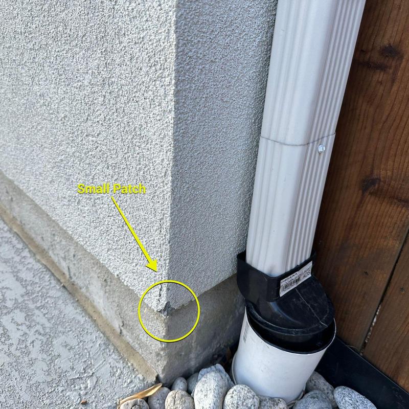 Stucco corner patch near downspout and concrete base Stucco corner patch near downspout and concrete base