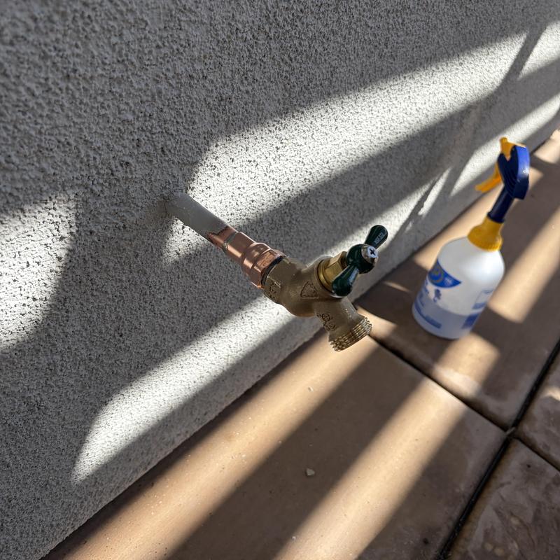 Brass hose bib installation on exterior wall