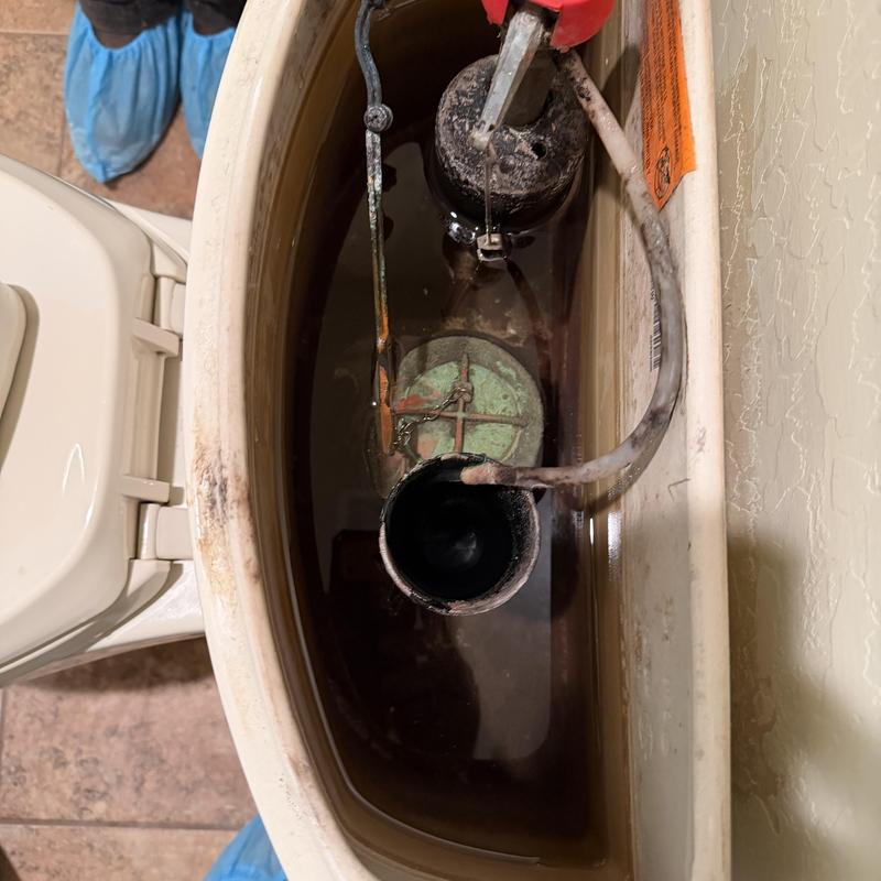 Toilet tank components with water and pliers inside Toilet tank components with water and pliers inside