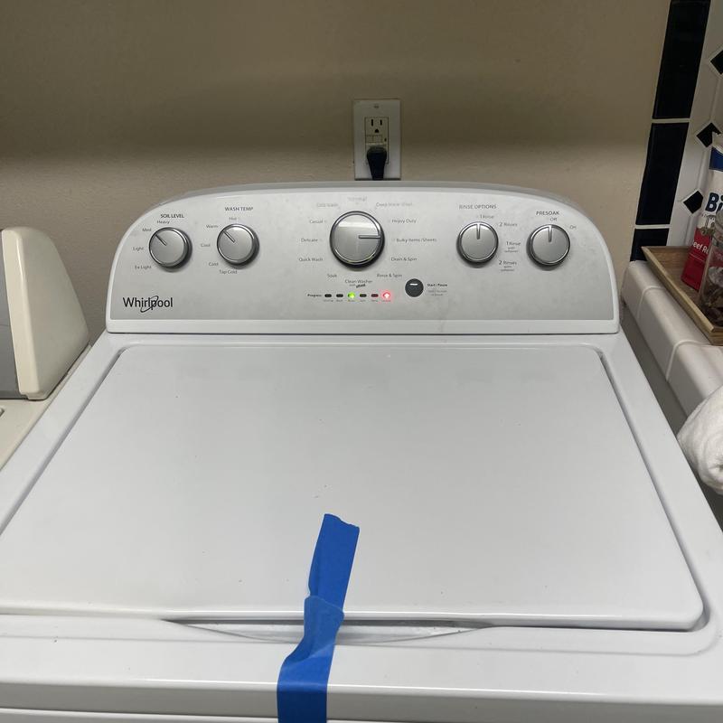 Washing machine control panel with blue tape on lid Washing machine control panel with blue tape on lid