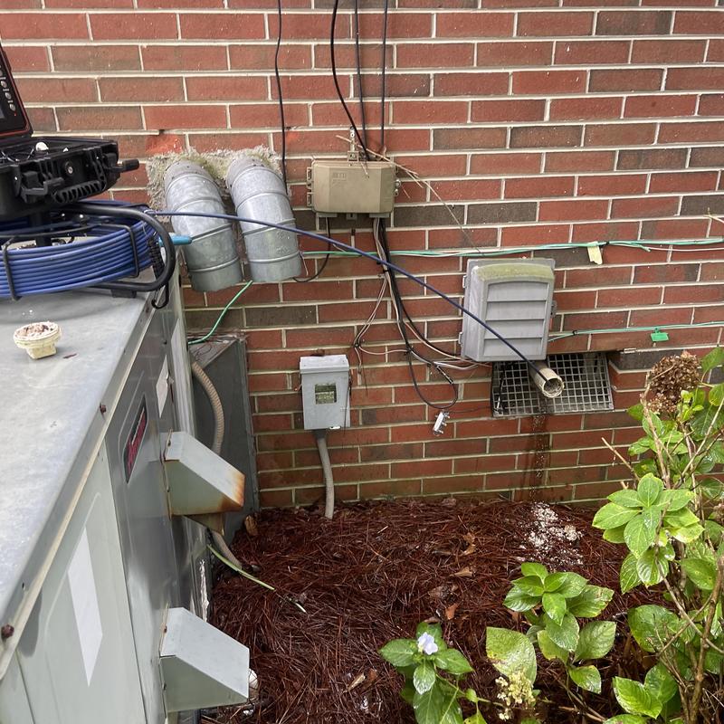 Sewer vent pipe with snake cable near brick wall Sewer vent pipe with snake cable near brick wall