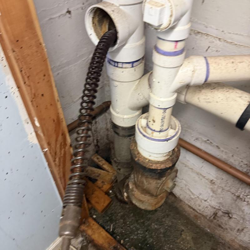 Main line sewer pipe with drain cleaning auger inserted Main line sewer pipe with drain cleaning auger inserted