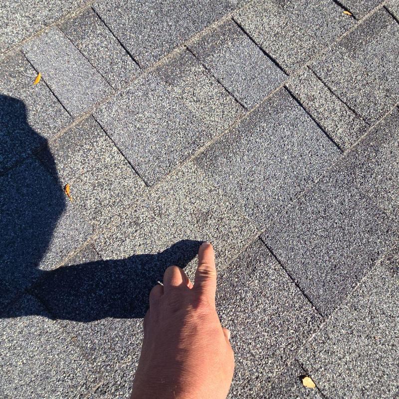 Asphalt shingle roof hail damage inspection with hand pointing