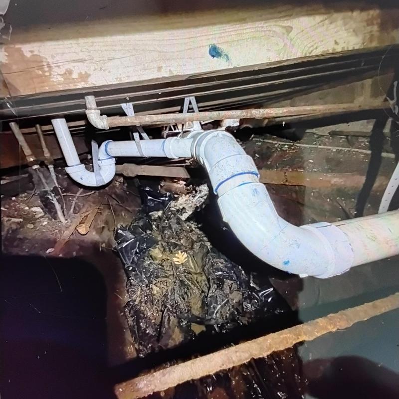 PVC drain pipe installation under home with elbow joints