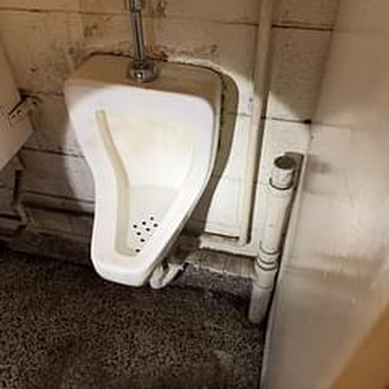 Urinal drain and pipe in commercial restroom