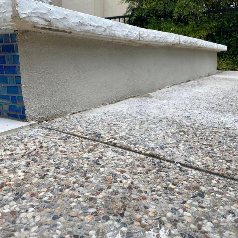 Concrete pool surround with blue tile and aggregate deck Concrete pool surround with blue tile and aggregate deck