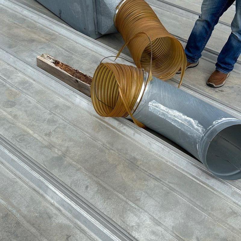 Metal roofing with damaged wood and ductwork on rooftop Metal roofing with damaged wood and ductwork on rooftop