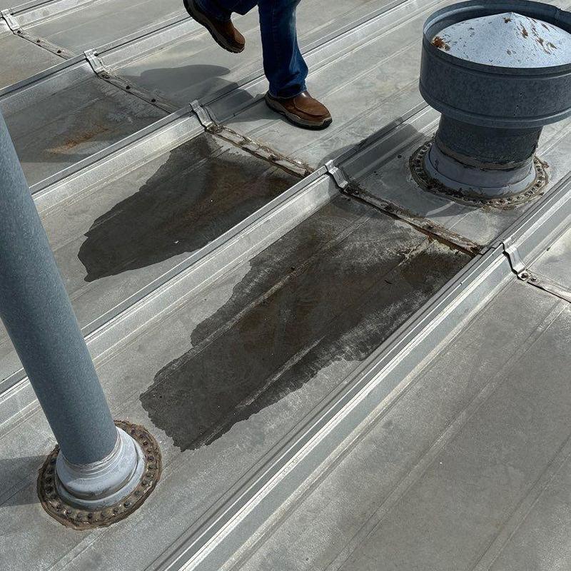 Metal roof seams and penetrations with rust patches Metal roof seams and penetrations with rust patches