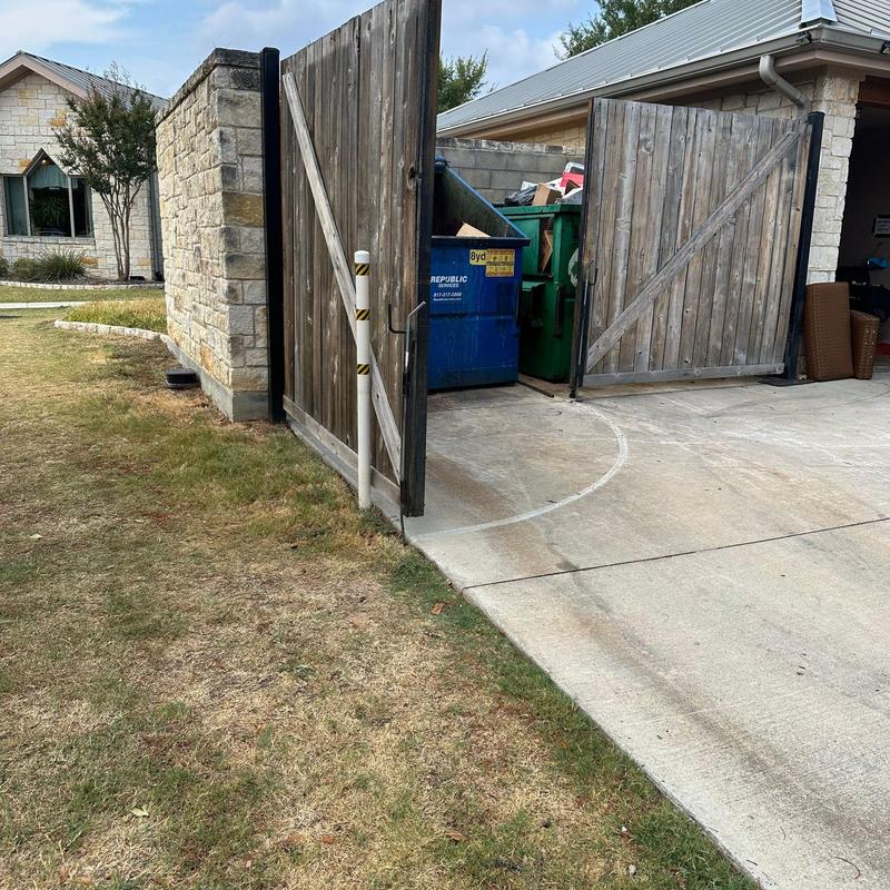 Stone trash enclosure with wood gate panels Stone trash enclosure with wood gate panels