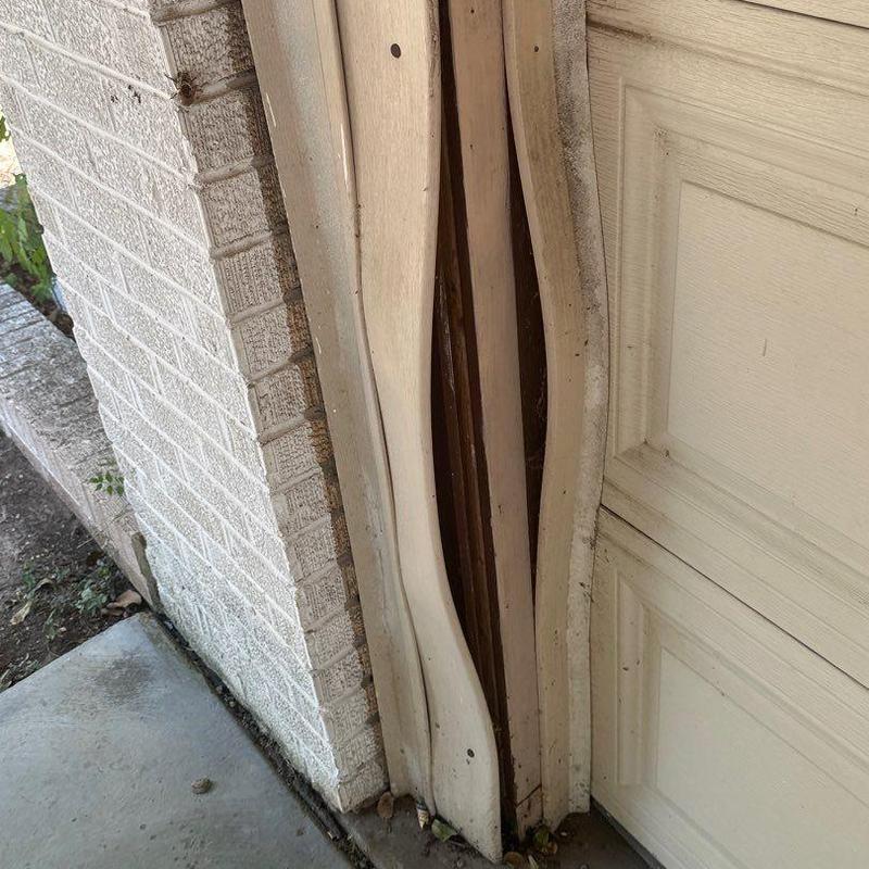 Garage door frame warped and separated from brick wall Garage door frame warped and separated from brick wall