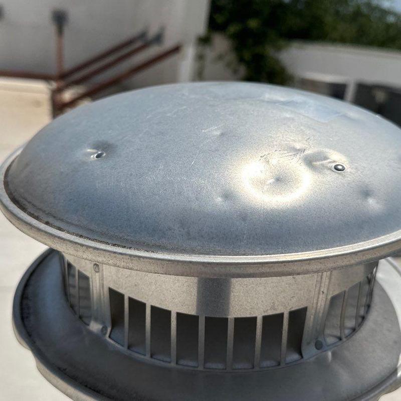 Metal roof vent cap with hail damage dents Metal roof vent cap with hail damage dents