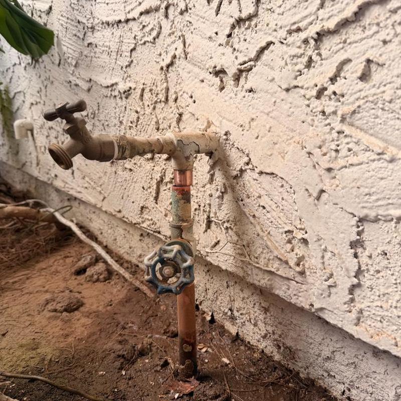 Outdoor water spigot with shut off valve on stucco wall