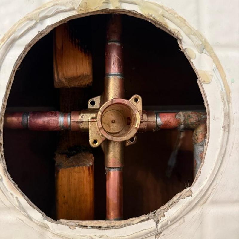 Shower valve body with connected copper pipes in wall cavity Shower valve body with connected copper pipes in wall cavity
