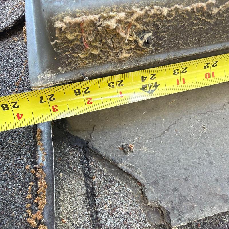 Roof shingles inspection with measuring tape on damage