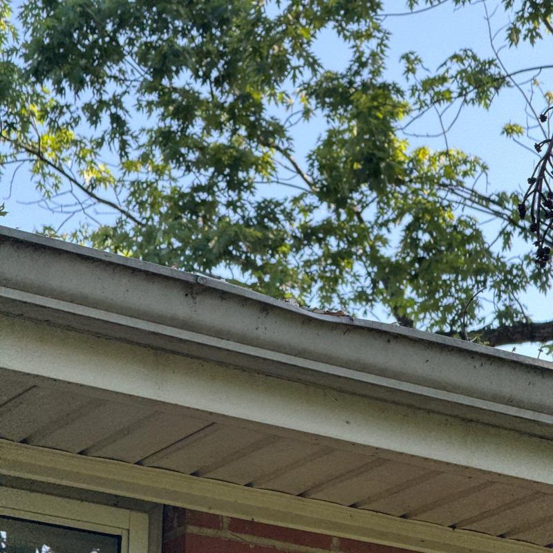 Roof edge gutter dented from hail damage inspection