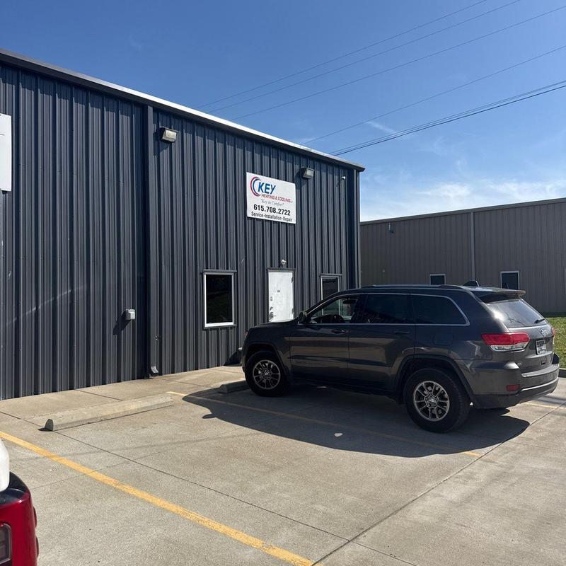 Metal building exterior with parked SUV