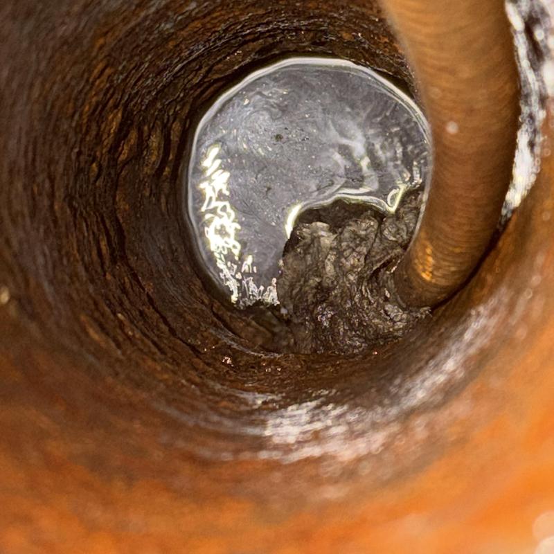 Main drain pipe clog with buildup inside wall