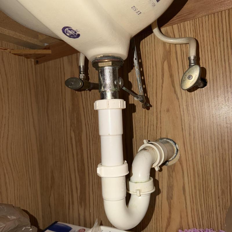 Sink drain trap and water shutoff valves under cabinet