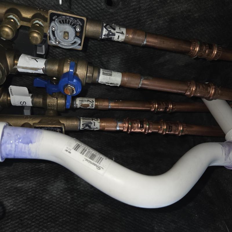 Copper water pipes with valves and white PVC pipe connections Copper water pipes with valves and white PVC pipe connections