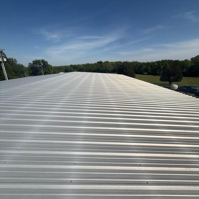 Metal roof panels on commercial building under clear sky