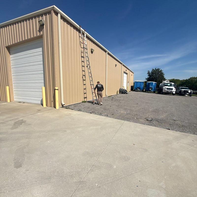 Metal building roof inspection with ladder setup